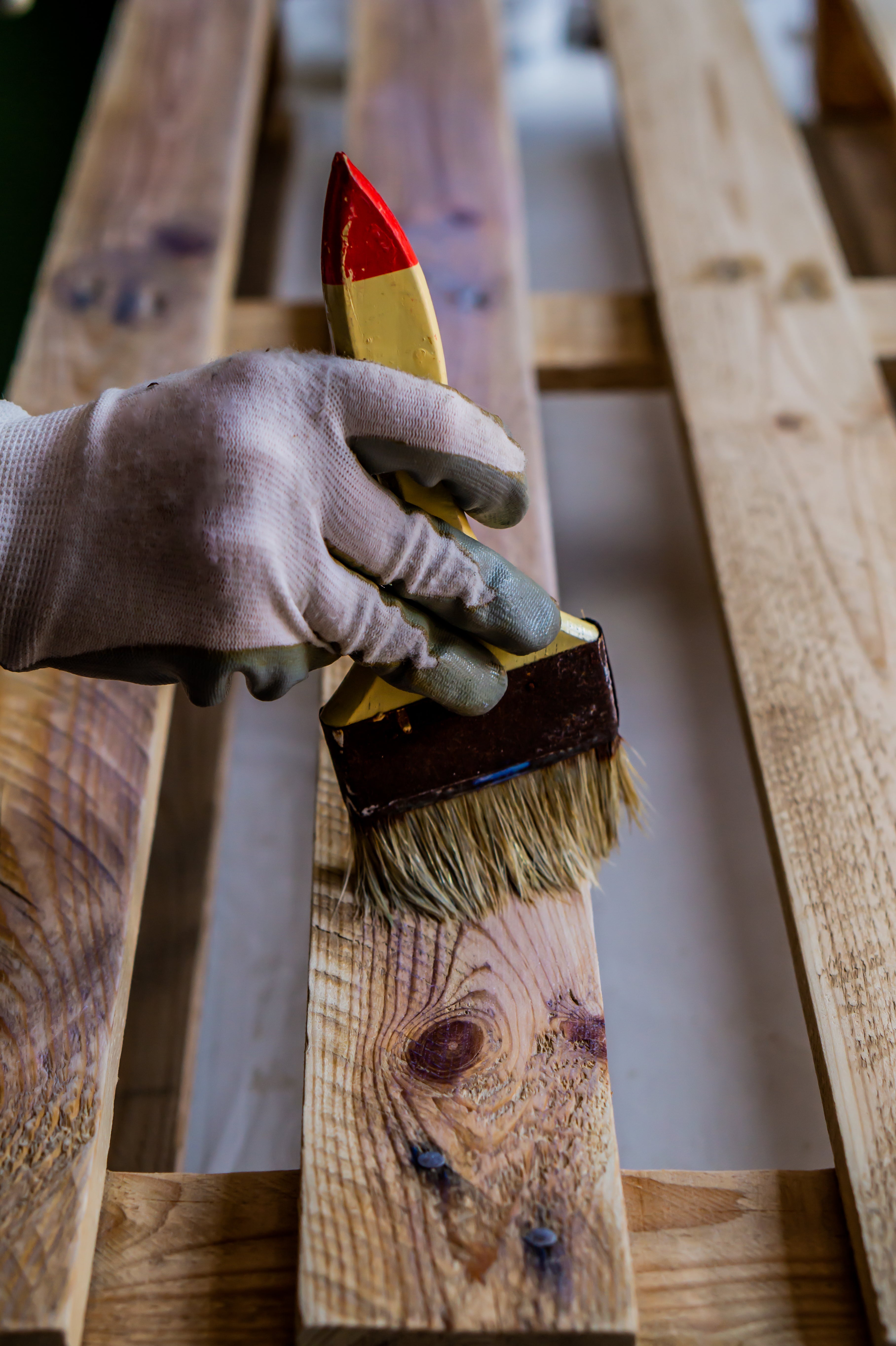 vertical-shot-person-painting-wooden-pallet-with-brush.jpg